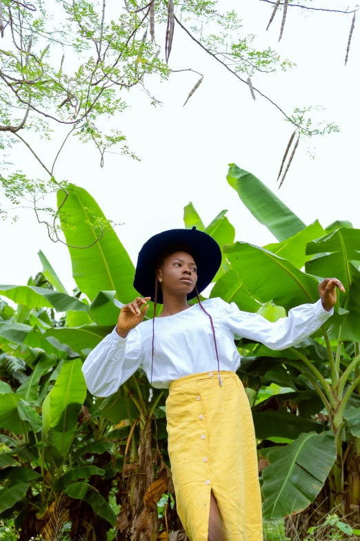 a woman standing in front of a banana tree, wearing farm clothes, in style of nadine ijewere, skies, student