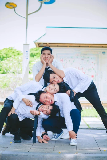 a group of people standing on top of each other, by Aguri Uchida, happening, yearbook photo, south korean male, fun pose, white uniform