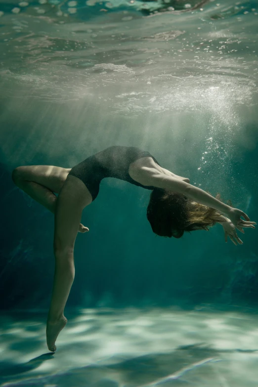 a woman in a bathing suit dives under water, an album cover, inspired by Brooke Shaden, unsplash contest winner, ignant, spiraling, taken in 2022, dancer