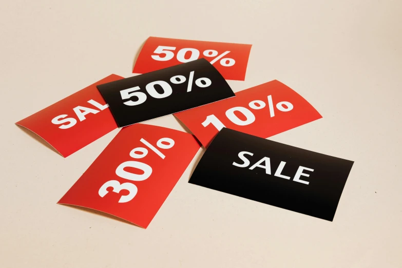 a pile of sale signs sitting on top of a table, by Emma Andijewska, unsplash, sōsaku hanga, red and black colour scheme, no - text no - logo, cardstock, 2 0 5 0 s