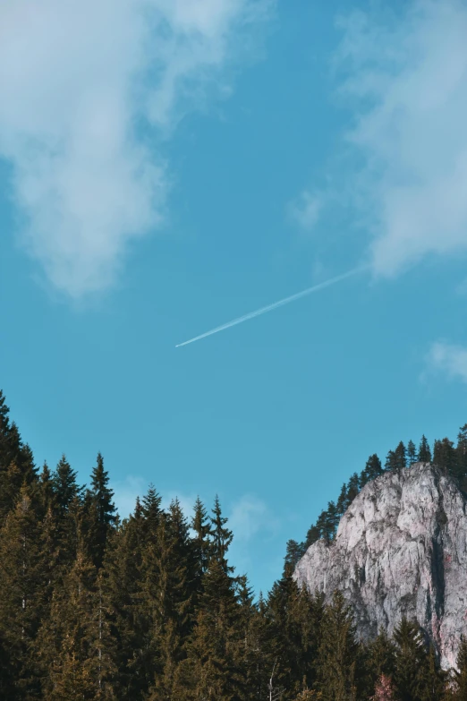 a man riding a snowboard on top of a snow covered slope, pexels contest winner, postminimalism, rocket launching into the sky, solo hiking in mountains trees, airplane in the sky, 🌲🌌