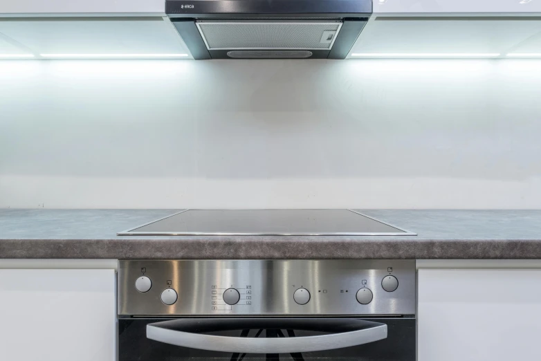 a stove top oven sitting inside of a kitchen, by Adam Marczyński, fluorescent ceiling lights, closeup - view, fan favorite, modern minimalist