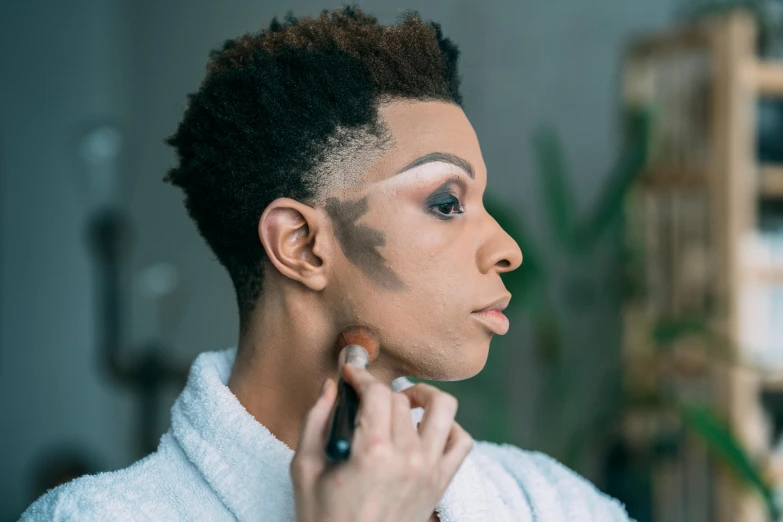 a woman in a bathrobe brushing her hair, trending on pexels, afrofuturism, face painting, masculine jawline, black makeup, shaven