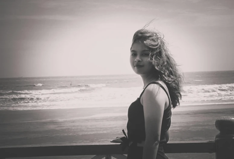 a black and white photo of a woman on the beach, a black and white photo, tumblr, renaissance, 🤤 girl portrait, cynthwave, postprocessed, desaturated color