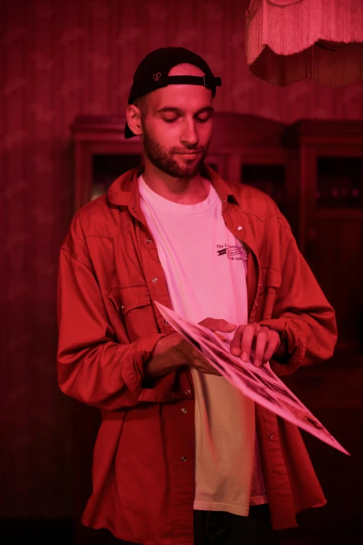 a man holding a pink umbrella in a dark room, an album cover, pexels contest winner, holography, dressed in red paper bags, zachary corzine, holding grimoire, hasan piker