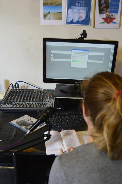 a woman sitting at a desk in front of a computer, an album cover, flickr, happening, studio microphone, radio equipment, in 2 0 1 5, teaching