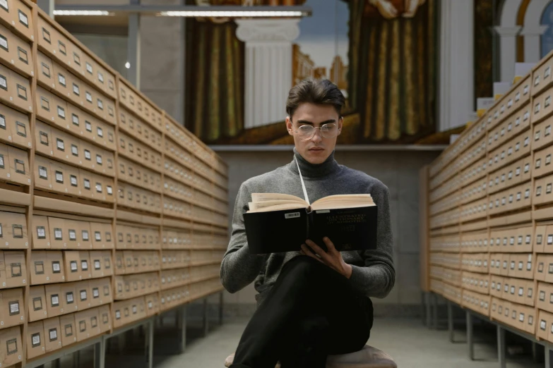 a man sitting on a stool reading a book, pexels contest winner, academic art, still from loki ( 2 0 2 1 ), grand library, college students, wearing reading glasses