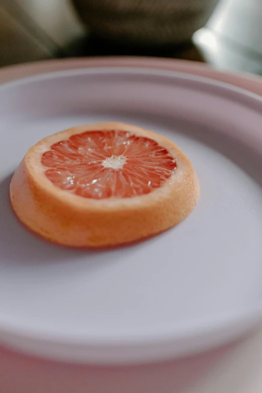 a grapefruit sitting on top of a white plate, b - roll, recipe, zoomed out shot, daytime