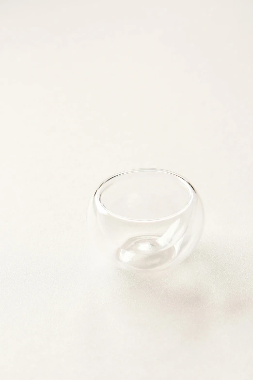 a glass cup sitting on top of a white table, shaped like torus ring, 35 mm product photo”, small in size, bubble