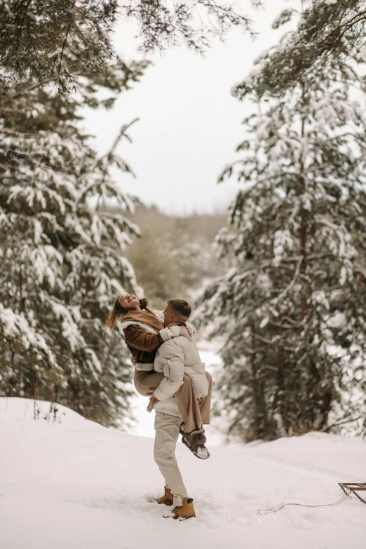 a man carrying a woman on his back in the snow, by Emma Andijewska, pexels contest winner, boreal forest, tan, slide show, in a tree