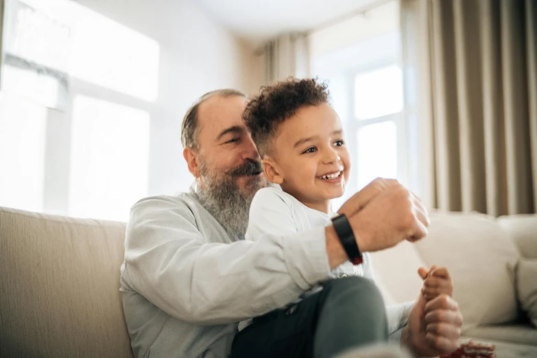 a man and a little boy sitting on a couch, pexels contest winner, grey beard, happy kid, avatar image, diverse