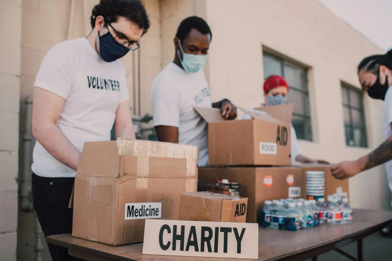 a group of people standing around a table with boxes, by Francis Helps, pexels contest winner, pandemic, 🚀🌈🤩, emergency, sustainable