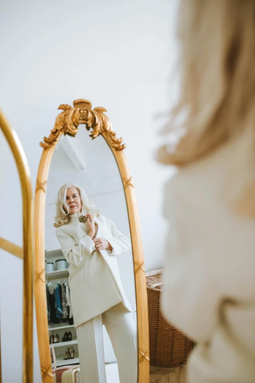 a woman that is standing in front of a mirror, by Sara Saftleven, pexels contest winner, rococo, dressed in an old white coat, white and gold color palette, blonde crea, premium quality
