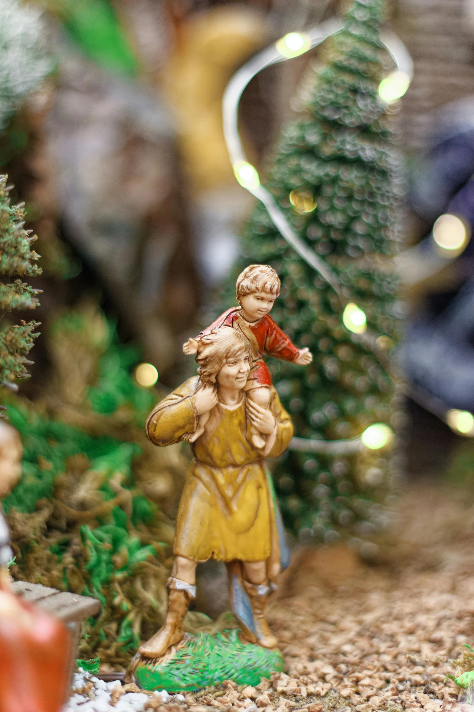 a couple of figurines sitting on top of a table, around tree babies running, with infant jesus, close up details, zoomed in