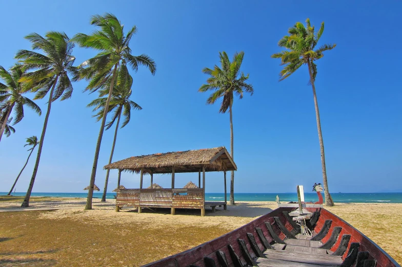 a boat sitting on top of a sandy beach, coconut trees, square, malika favre, big sky