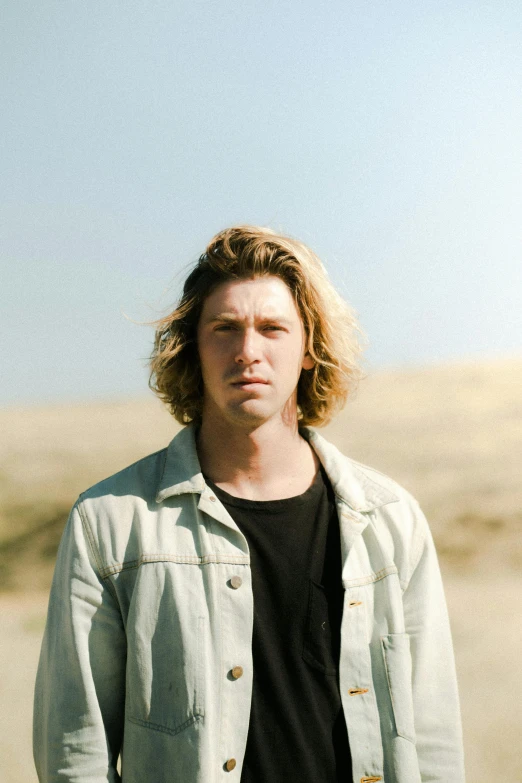 a man standing in the middle of a desert, an album cover, by Jacob Toorenvliet, renaissance, parted hair, washed out background, confident looking, beaches