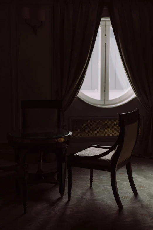 a chair sitting in front of a window in a dark room, inspired by Jean Tabaud, unsplash, tonalism, drapes, marble room, silhoutte, armchairs
