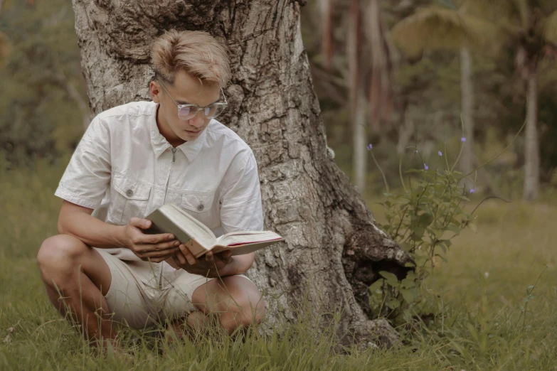 a man sitting under a tree reading a book, by Adam Marczyński, pexels contest winner, hyperrealism, blonde guy, white reading glasses, avatar image, lachlan bailey