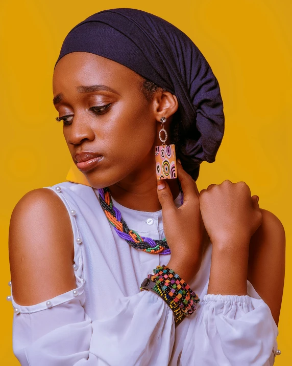 a woman wearing a head scarf and earrings, inspired by Ras Akyem, trending on pexels, afrofuturism, full body image, multi colour, black jewellery, detailed product image