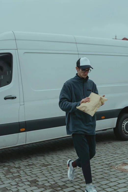 a man walking in front of a white van, pexels contest winner, bread, postage, grey, full body length