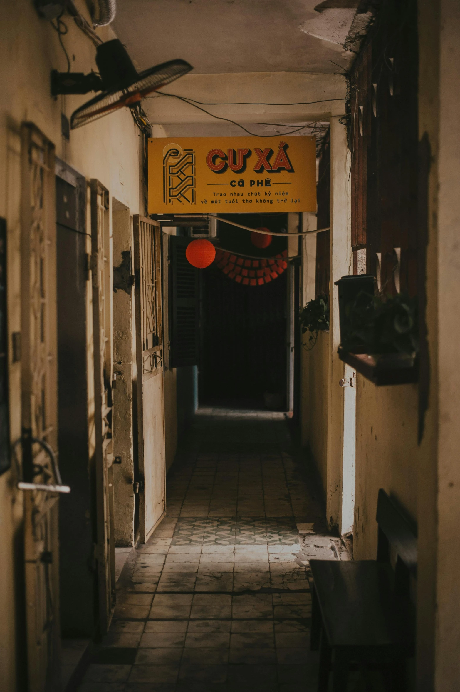 a narrow hallway with a sign hanging from the ceiling, by Géza Dósa, on an indian street, lights on, jia, a quaint