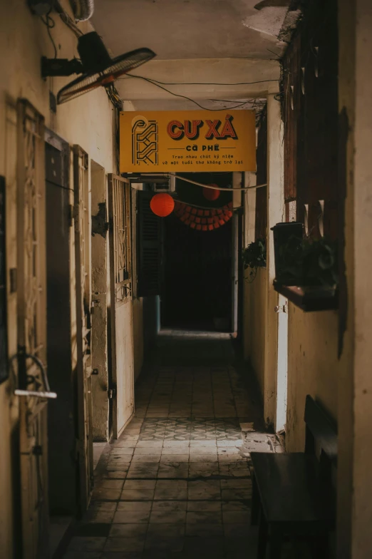 a narrow hallway with a sign hanging from the ceiling, by Géza Dósa, on an indian street, lights on, jia, a quaint