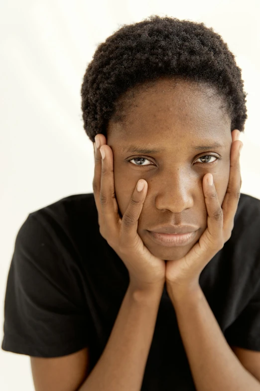 a close up of a person with their hands on their face, by Lily Delissa Joseph, clean shaven face, arms folded, looking serious, maria borges