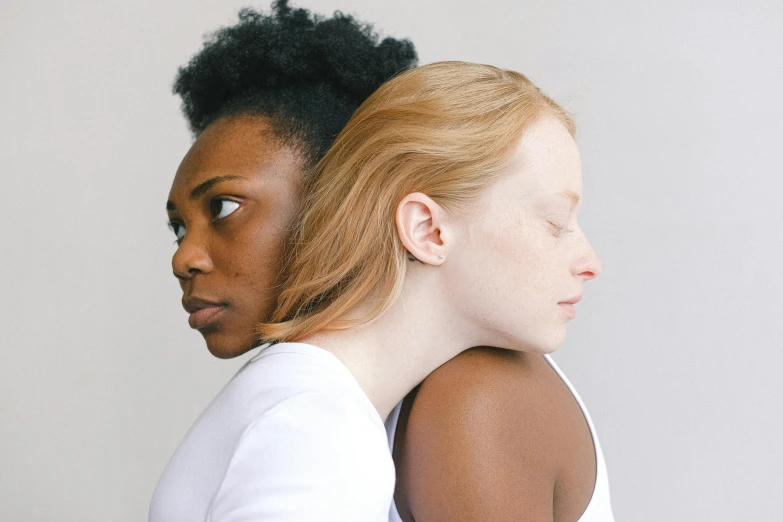 a couple of women standing next to each other, by Carey Morris, trending on pexels, renaissance, her skin is light brown, ivory and ebony, embraced, head and shoulders view