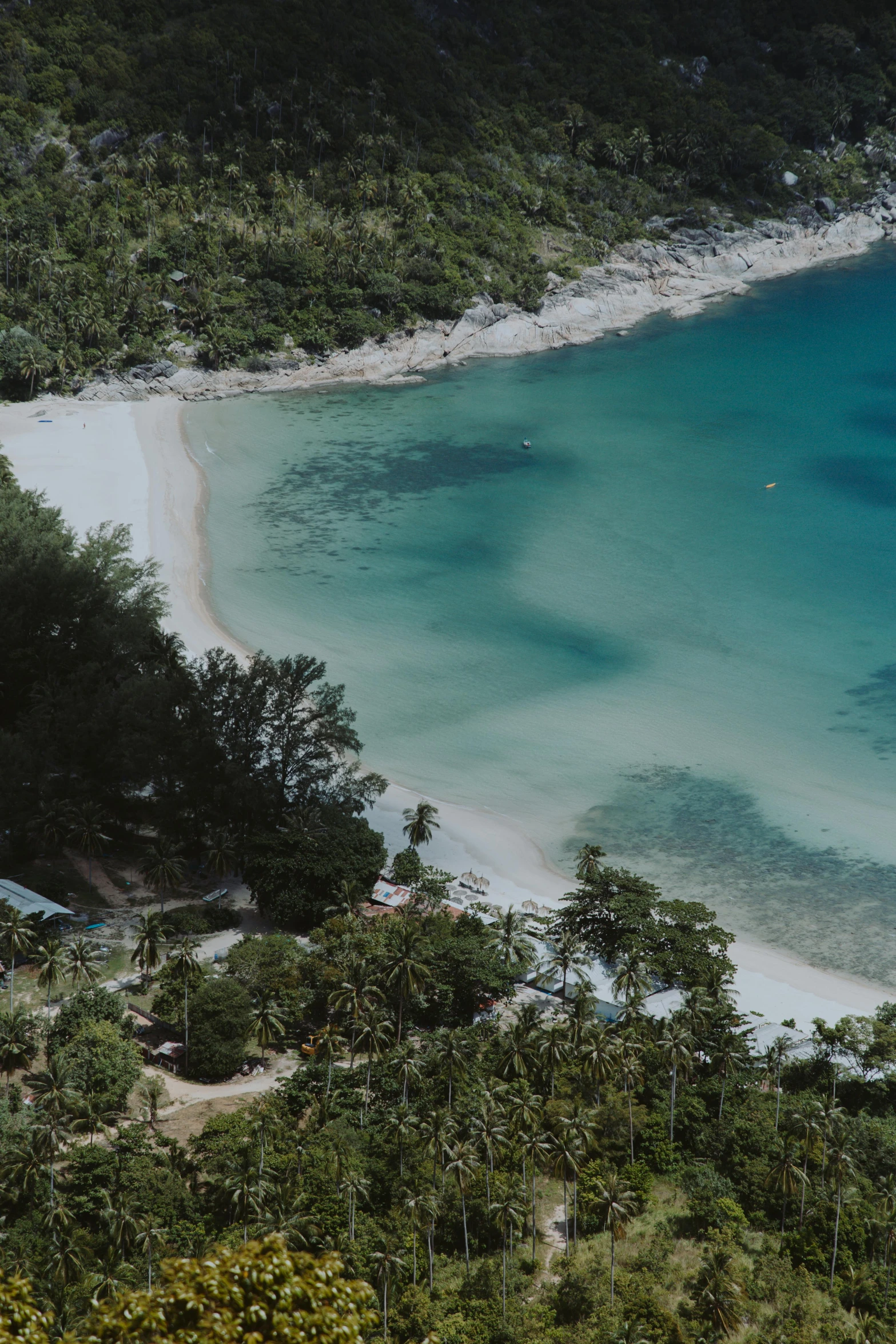 a view of a beach from the top of a hill, crystal waters, exterior shot, rum, lush surroundings