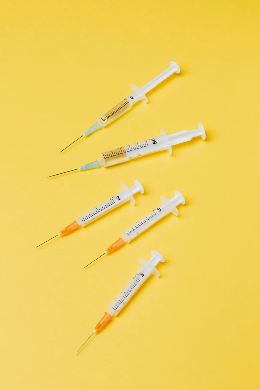 a bunch of syops sitting on top of a yellow surface, unsplash, conceptual art, syringes, japanese collection product, detailed product shot, 3 - piece