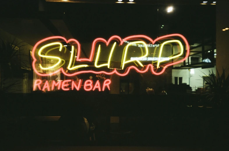 a neon sign that says slurp ramen bar, inspired by Louis Faurer, unsplash, 2000s photo, scanned, silly, 2 0 0 2 photo