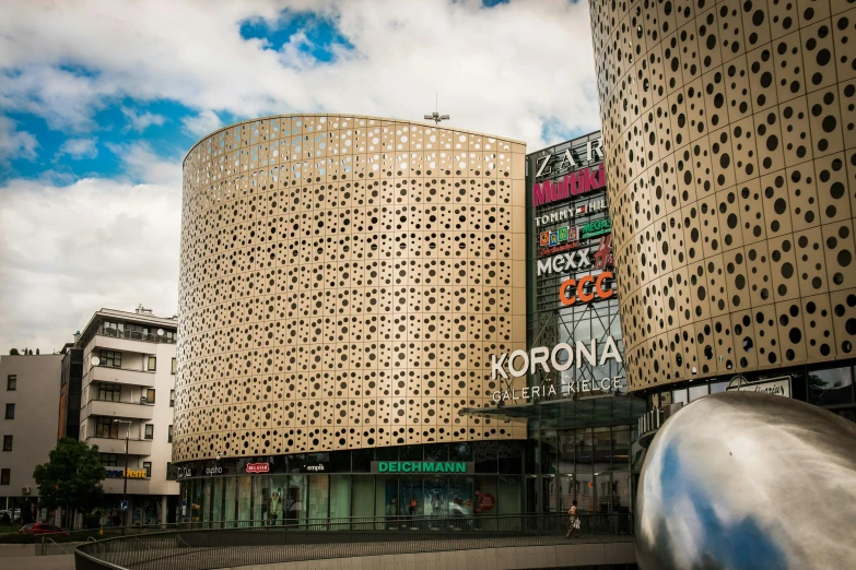 a very tall building with a lot of windows, an album cover, by karlkka, art nouveau, on a futuristic shopping mall, perforated metal, corona, round buildings in background