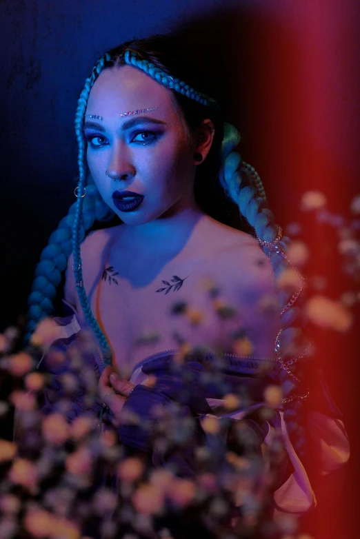 a woman standing next to a bunch of flowers, an album cover, inspired by Aya Goda, unreal engine : : rave makeup, blue braided hair, cosplay on black harley queen, pose 4 of 1 6