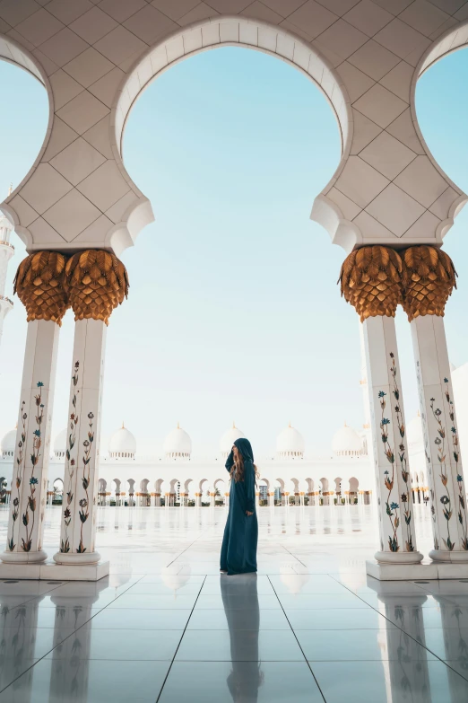 a woman standing in the middle of a large building, pexels contest winner, arabesque, arab inspired, pure gold pillars, al fresco, structures