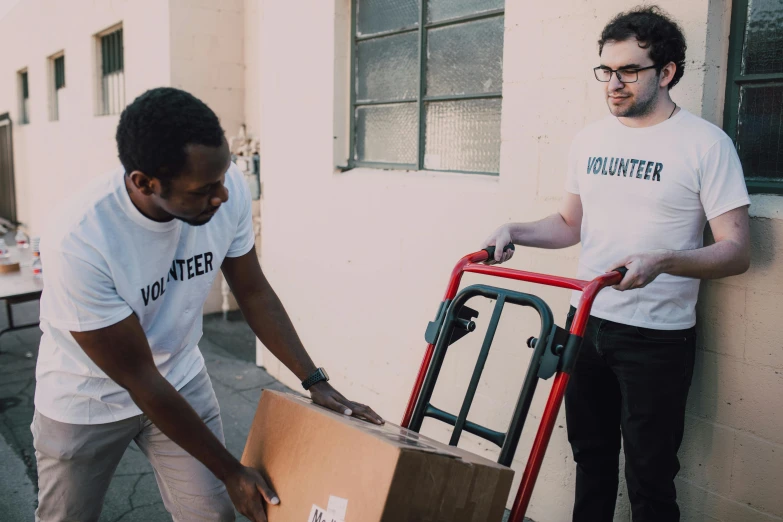 two men unloading a box onto a hand truck, by Francis Helps, pexels contest winner, hurufiyya, wearing pants and a t-shirt, avatar image, virgil abloh, lachlan bailey