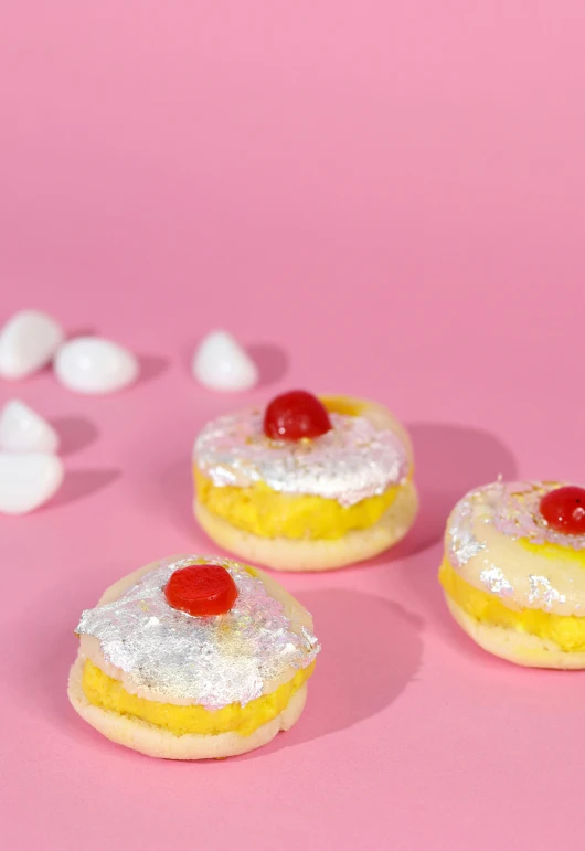 three pastries on a pink surface with marshmallows, inspired by Pearl Frush, reddit, 🍸🍋, white and yellow scheme, the mighty donut, miami vice