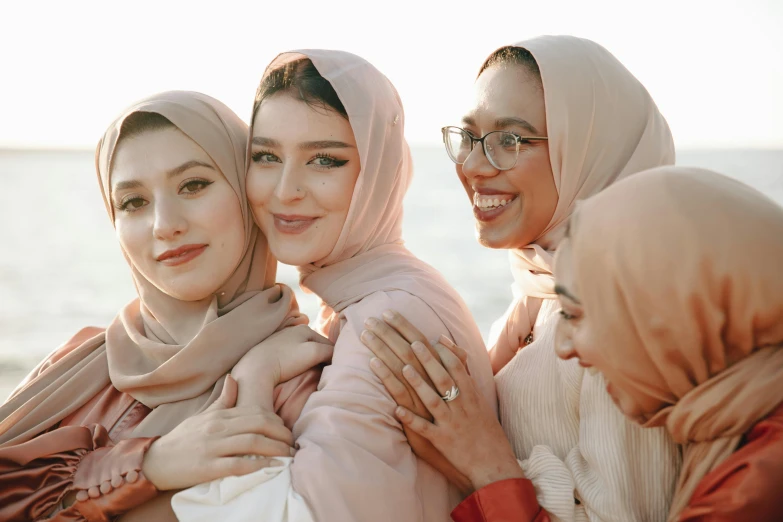 a group of women standing next to each other, a picture, trending on pexels, hurufiyya, wearing a head scarf, photoshoot for skincare brand, pale - skinned, portrait of women embracing