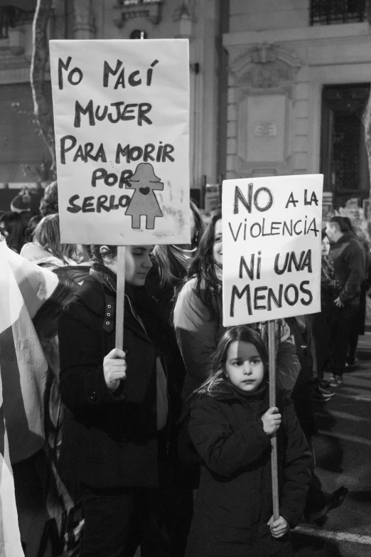 a group of people holding signs in front of a building, a black and white photo, by Glòria Muñoz, flickr, feminist art, alena aenami and lilia alvarado, mother, with violence, no women