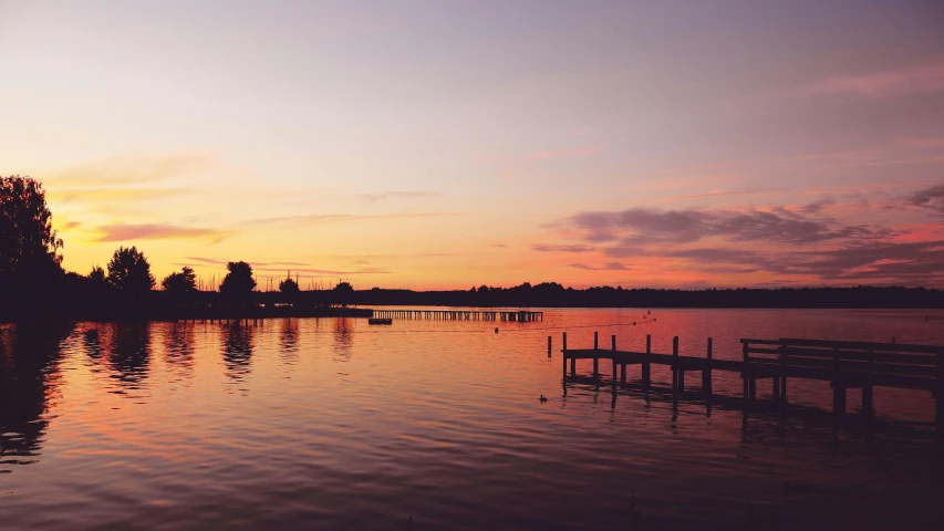 a body of water with a dock in the middle of it, pexels contest winner, sunset colors, faded glow, lakeside, instagram post