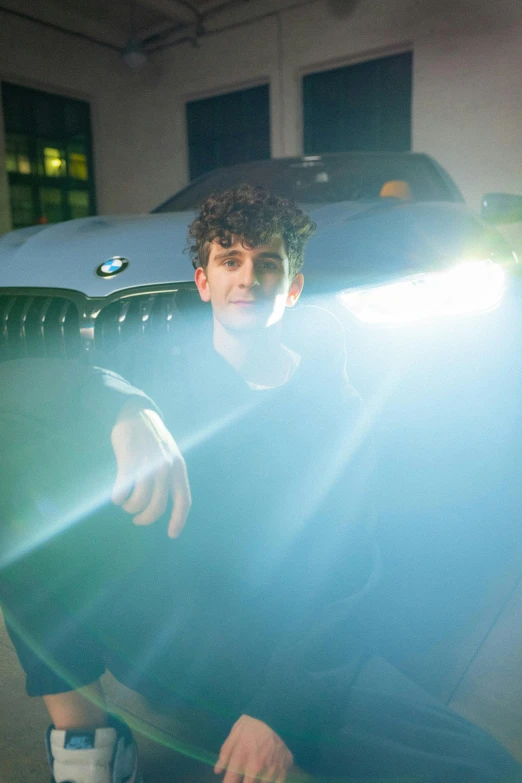 a man that is standing in front of a car, inspired by John Luke, glowing internal light, press shot, ethan klein, rimlight