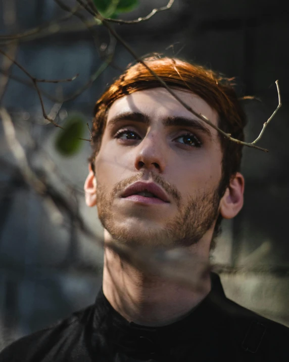 a man with red hair wearing a black shirt, an album cover, inspired by Francisco Oller, trending on pexels, the non-binary deity of spring, borja, lovingly looking at camera, gal yosef