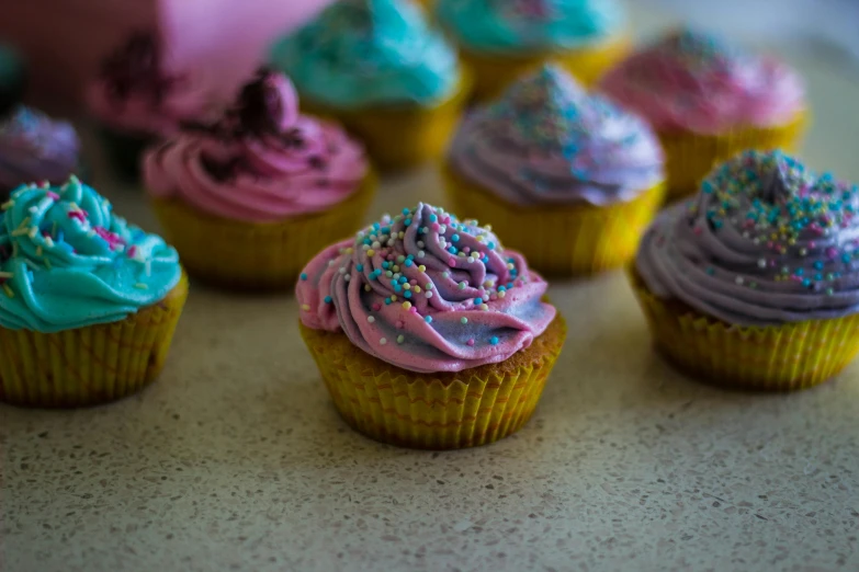 a table topped with cupcakes covered in frosting, a stipple, pexels, multicolor, fan favorite, dessert, pearlescent