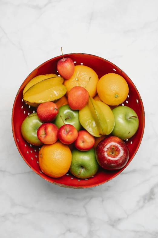 a red bowl filled with lots of different types of fruit, full product shot, apple orange, medium, misty