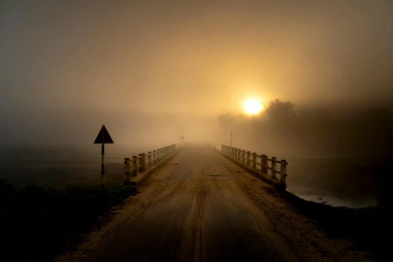 a bridge in the middle of a foggy field, pexels contest winner, golden hour 8k, dark wet road, yellow, australian