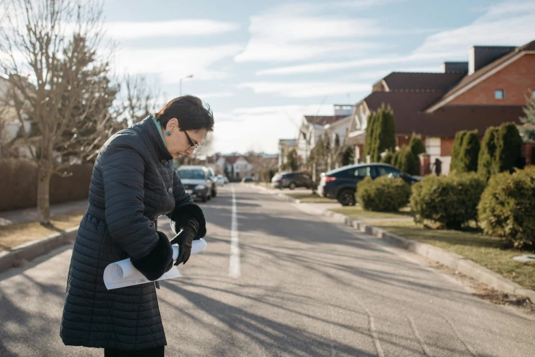 a woman standing in the middle of a street, wearing gloves, neighborhood, profile image, romanian