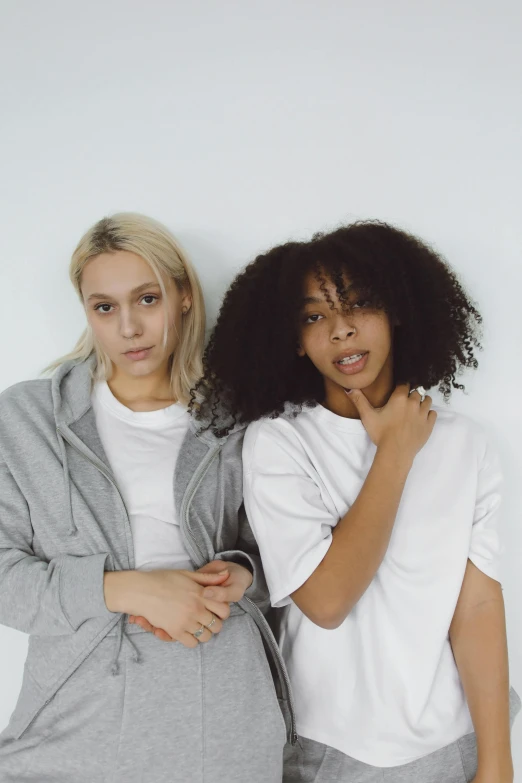 a couple of women standing next to each other, trending on unsplash, antipodeans, her hair is white, yzy gap, photo from a promo shoot, black teenage girl