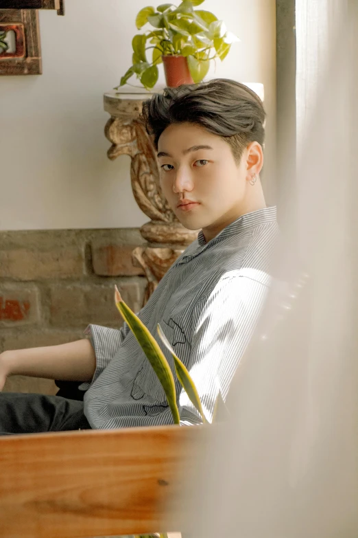 a man sitting on a couch using a laptop computer, an album cover, inspired by Joong Keun Lee, trending on pexels, realism, lovingly looking at camera, boy staring at the window, androgynous male, profile pic