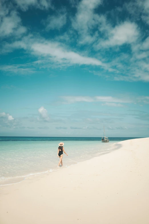 a woman walking on a beach next to the ocean, great barrier reef, white beaches, award - winning photo ”, secluded