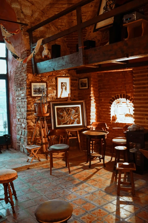 a living room filled with furniture and a fire place, by Jakub Husnik, pexels contest winner, arts and crafts movement, iconostasis in the bar, old brick walls, picture of a loft in morning, dimly-lit cozy tavern