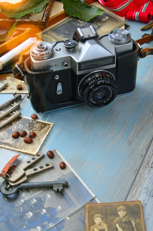 a camera sitting on top of a wooden table, a still life, inspired by William Harnett, art photography, brown and cyan blue color scheme, tools and junk on the ground, vintage - w 1 0 2 4, photograph quality